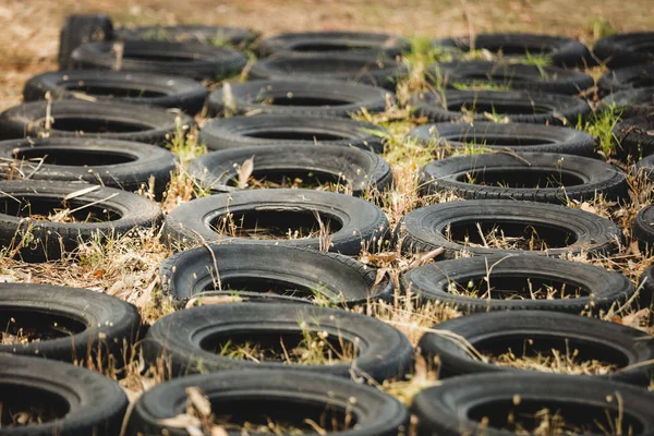 Banden in een rij geplaatst op grond voor opleiding hindernissenparcours — Stockfoto