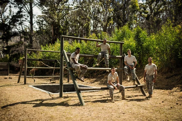 Soldados sentados en la pista de obstáculos en el campo de entrenamiento —  Fotos de Stock