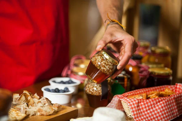 Staff checking pickle jar at counter in market — Stock Photo, Image