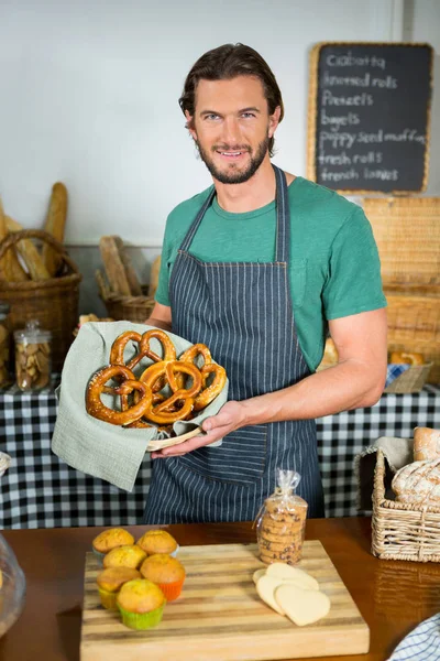 Ritratto di bastone maschio con cesto di pretzel al bancone — Foto Stock