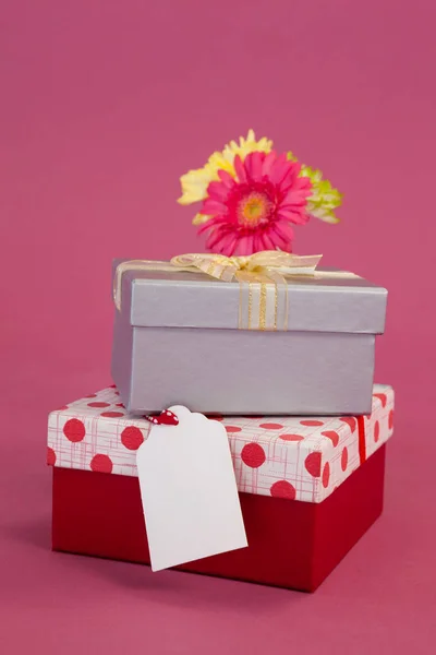 Montón de cajas de regalo con etiqueta y flores — Foto de Stock