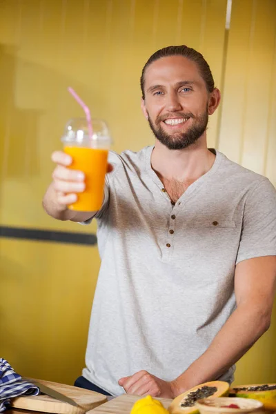 Personal masculino sosteniendo vaso de zumo de naranja en sección orgánica — Foto de Stock