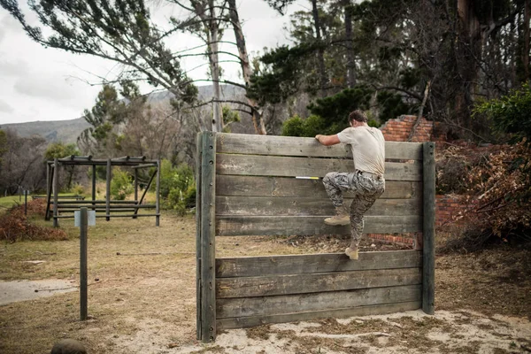 Soldado escalando pared de madera en campo de entrenamiento — Foto de Stock