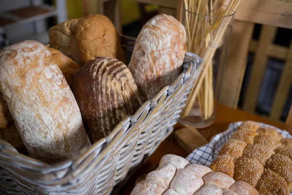 Крупним планом свіжий хліб у плетеному кошику на стійці — стокове фото