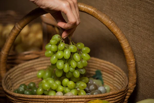 Mão de mulher comprando cacho de uvas — Fotografia de Stock