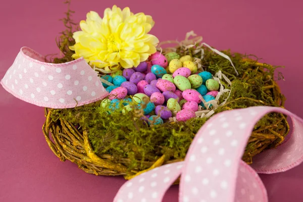 Easter eggs in wicker basket with a flower — Stock Photo, Image