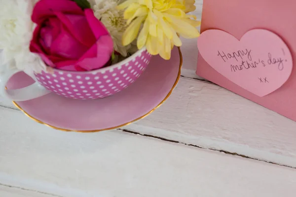 Close-up of paper bag with message and fresh flowers — Stock Photo, Image