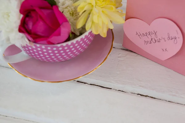 Primer plano de la bolsa de papel con mensaje y flores frescas —  Fotos de Stock