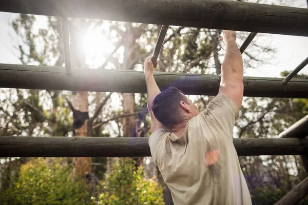 Soldier climbing monkey bars — Stock Photo, Image