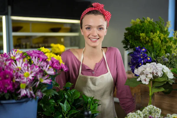 Felice fiorista donna in piedi nel negozio di fiori — Foto Stock