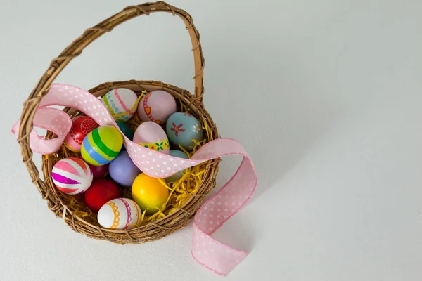 用丝带在柳条篮子里的各种复活节彩蛋。 — 图库照片