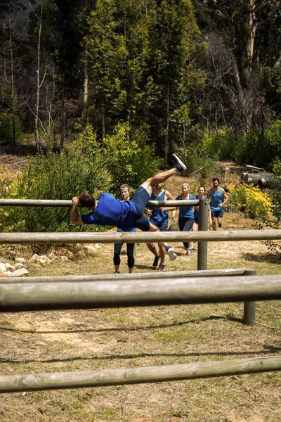 Les gens sautent par-dessus les obstacles pendant le parcours d'obstacles — Photo