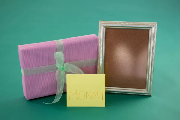 Geschenkbox, Fotorahmen mit Text Mama auf Karte vor grünem Hintergrund — Stockfoto