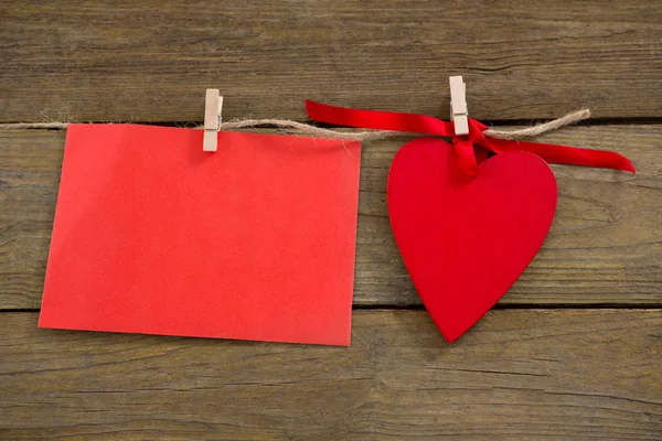 Red hearts and envelope with cloth peg hanging on rope — Stock Photo, Image