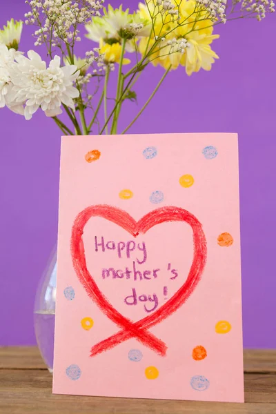 Открытка на день матери с цветочной вазой на столе — стоковое фото