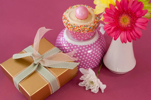 Крупный план подарочной коробки, вазы с кексами и цветами — стоковое фото