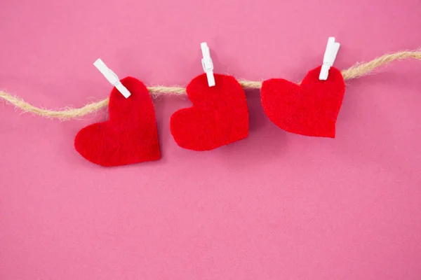 Red hearts with cloth peg hanging on rope — Stock Photo, Image