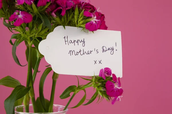 Close-up of happy mothers day card on flowers — Stock Photo, Image