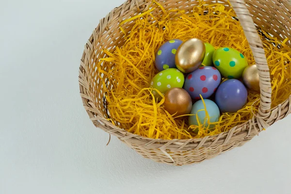 Hasır sepet içinde çeşitli Paskalya yumurtaları — Stok fotoğraf