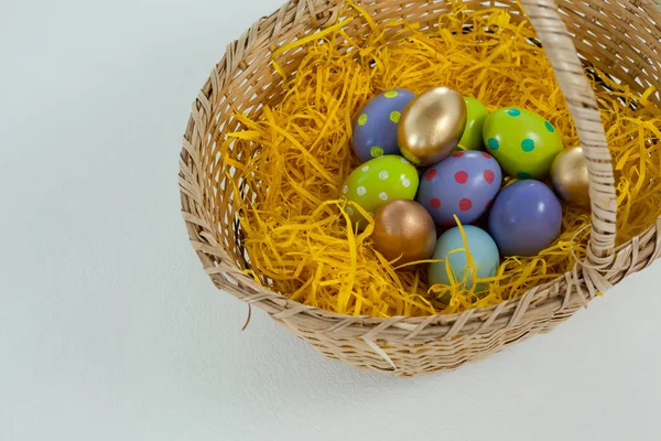 Various Easter eggs in wicker basket — Stock Photo, Image