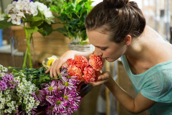 Woman smelling a bunch of flowers — Stock Photo, Image