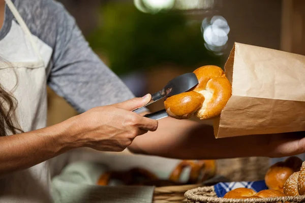 Personál balení chleba do papírového sáčku na pekárnu — Stock fotografie