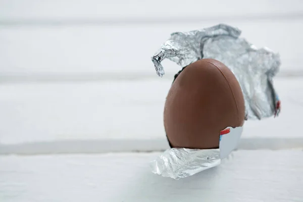 Ovo de Páscoa de chocolate em papel alumínio no fundo branco — Fotografia de Stock