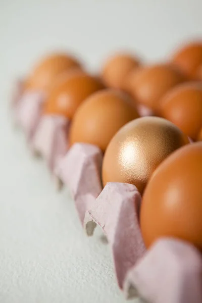 Ovos de Páscoa em caixa na superfície branca — Fotografia de Stock