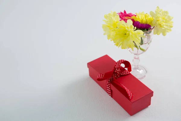 Pudełko na prezent i kwiaty w szkle — Zdjęcie stockowe