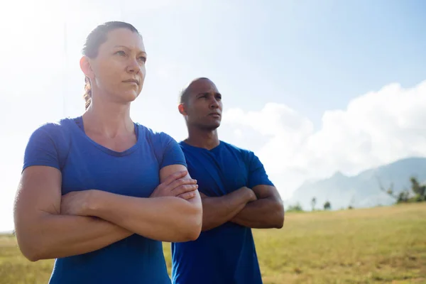 Entrenador femenino y entrenador masculino de pie con los brazos cruzados — Foto de Stock