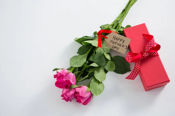 Presentförpackning och massa rosa ros med glad mödrar dag tagg — Stockfoto