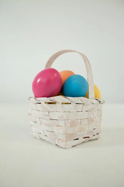 Various Easter eggs in wicker basket — Stock Photo, Image