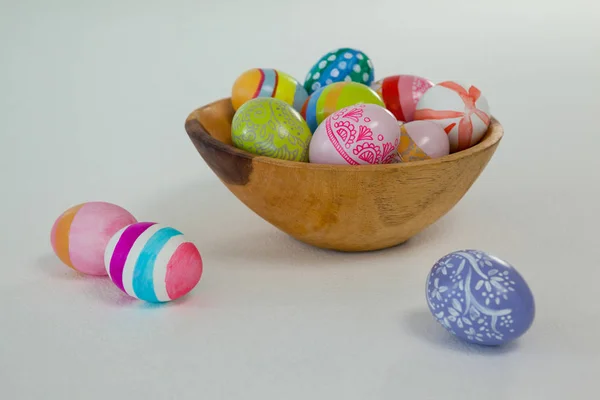 Colorful Easter eggs in wooden bowl — Stock Photo, Image