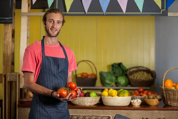 Portrait du personnel masculin tenant des tomates fraîches en section biologique — Photo