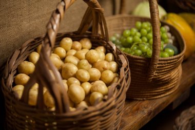Basket full of grapes and potato at counter clipart