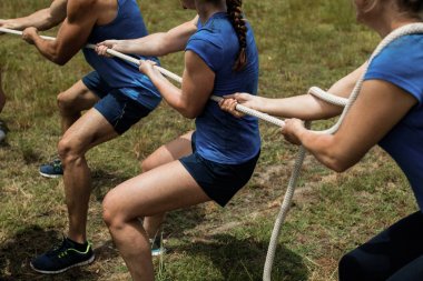 People playing tug of war during obstacle training course clipart