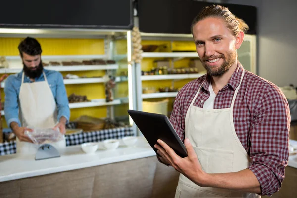 Porträt lächelnder männlicher Mitarbeiter mit digitalem Tablet in der Nähe der Fleischtheke — Stockfoto