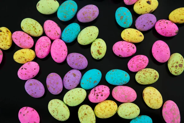 Ovos de Páscoa multicoloridos em fundo preto — Fotografia de Stock