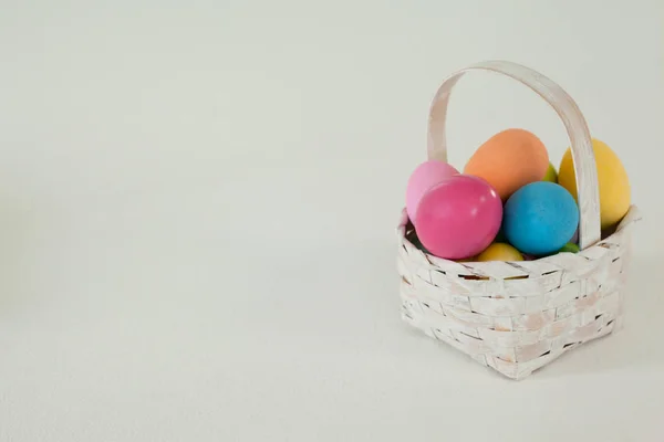 Různé velikonoční vejce v proutěném koši — Stock fotografie
