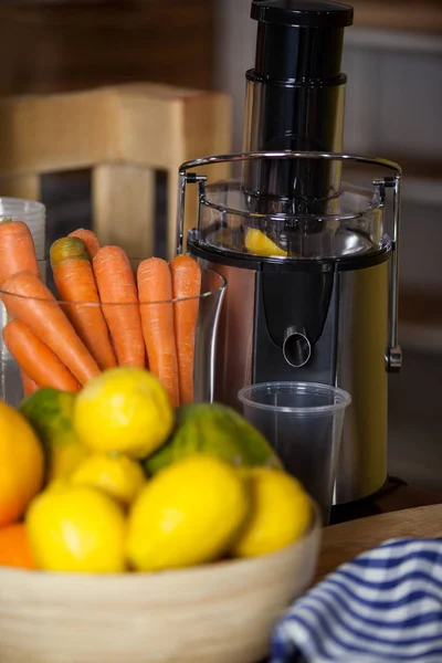 Exprimidor con zanahoria y limón en un bol — Foto de Stock