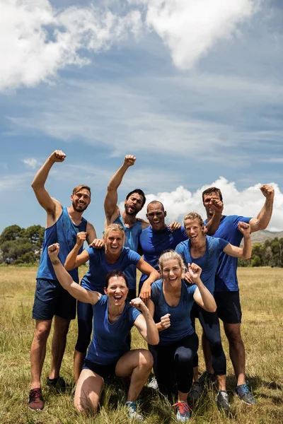 Grupo de personas en forma posando juntas en el campo de entrenamiento —  Fotos de Stock