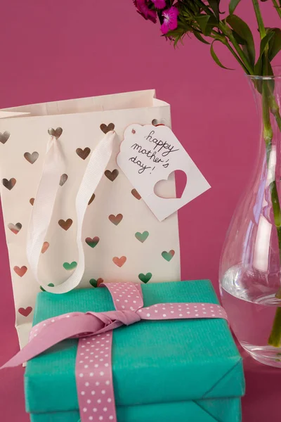 Primer plano de la caja de regalo, bolsa de papel y florero de flores —  Fotos de Stock