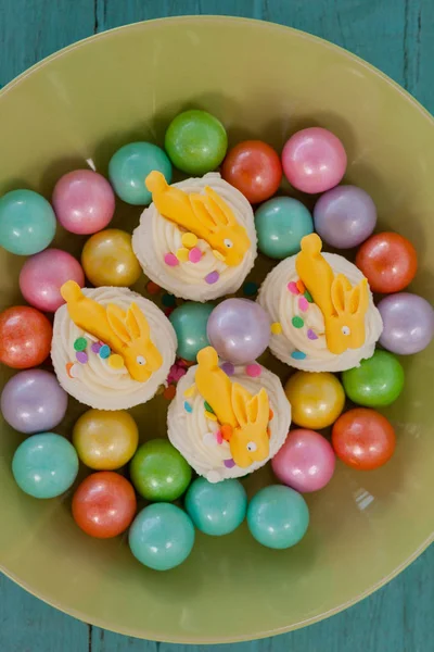 Bunte Pralinen und Cupcakes in Schale — Stockfoto