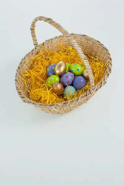 Hasır sepet içinde çeşitli Paskalya yumurtaları — Stok fotoğraf