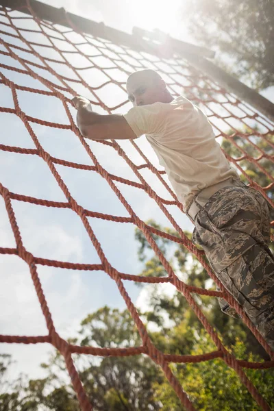 Katonai katona hegymászó kötél alatt akadálypályán — Stock Fotó