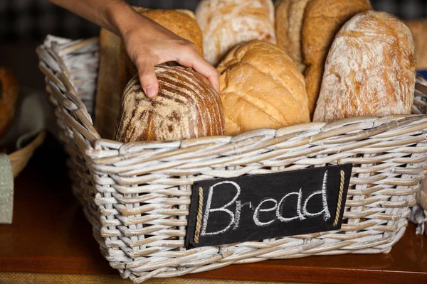 Női alkalmazottak gazdaság kenyerek a számlálót a pékség bolt — Stock Fotó