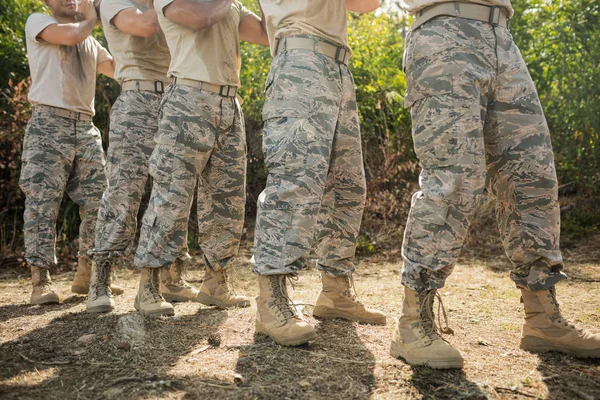 Soldaten, die einen Baumstamm tragen — Stockfoto