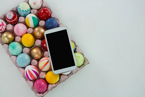 卵の箱で塗られたイースターエッグに置い携帯 — ストック写真