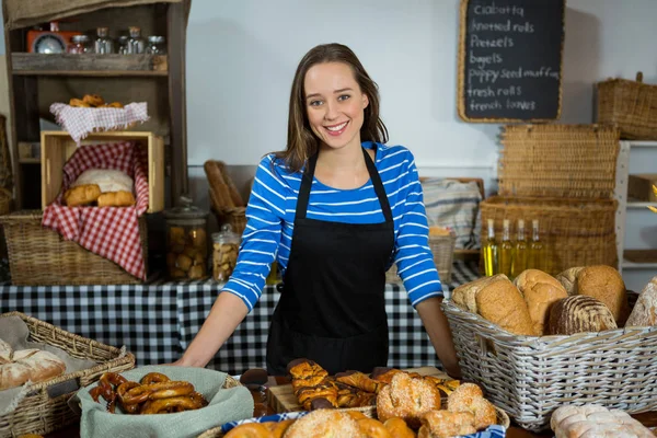 Portrait of smiling female staff standing at bread counter — Stock Photo, Image