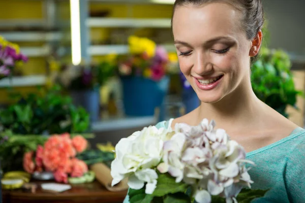 Sorrindo mulher segurando um monte de flores — Fotografia de Stock